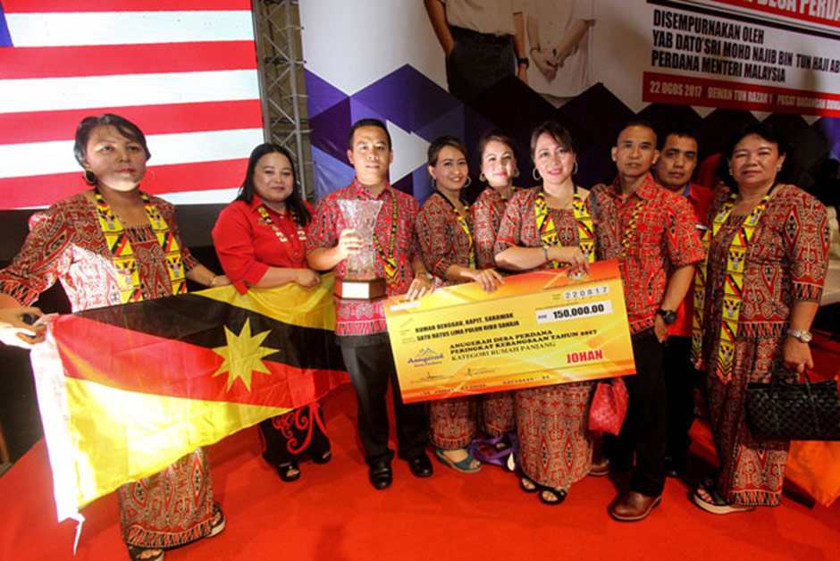 The Rumah Bengau Longhouse representatives showing their trophy and mock cheque at the Desa Perdana 2017 Award at the Putra World Trade Centre, Kuala Lumpur. – Photo Credit: Bernama