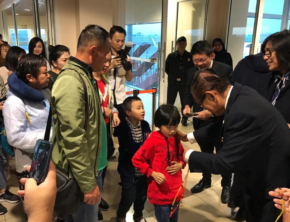 Assistant Minister of Tourism, Datuk Lee Kim Shin, garlanding disembarking passengers with Sarawak-themed bead necklaces.